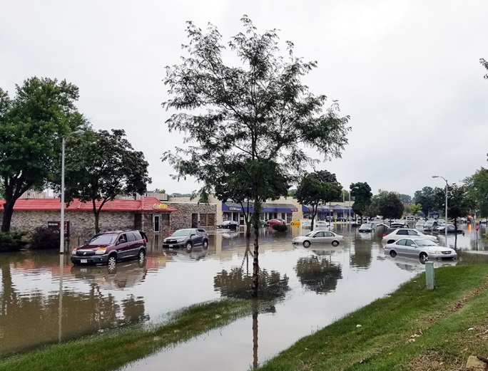 Image depicting flooded street with buildings in a flood-prone area